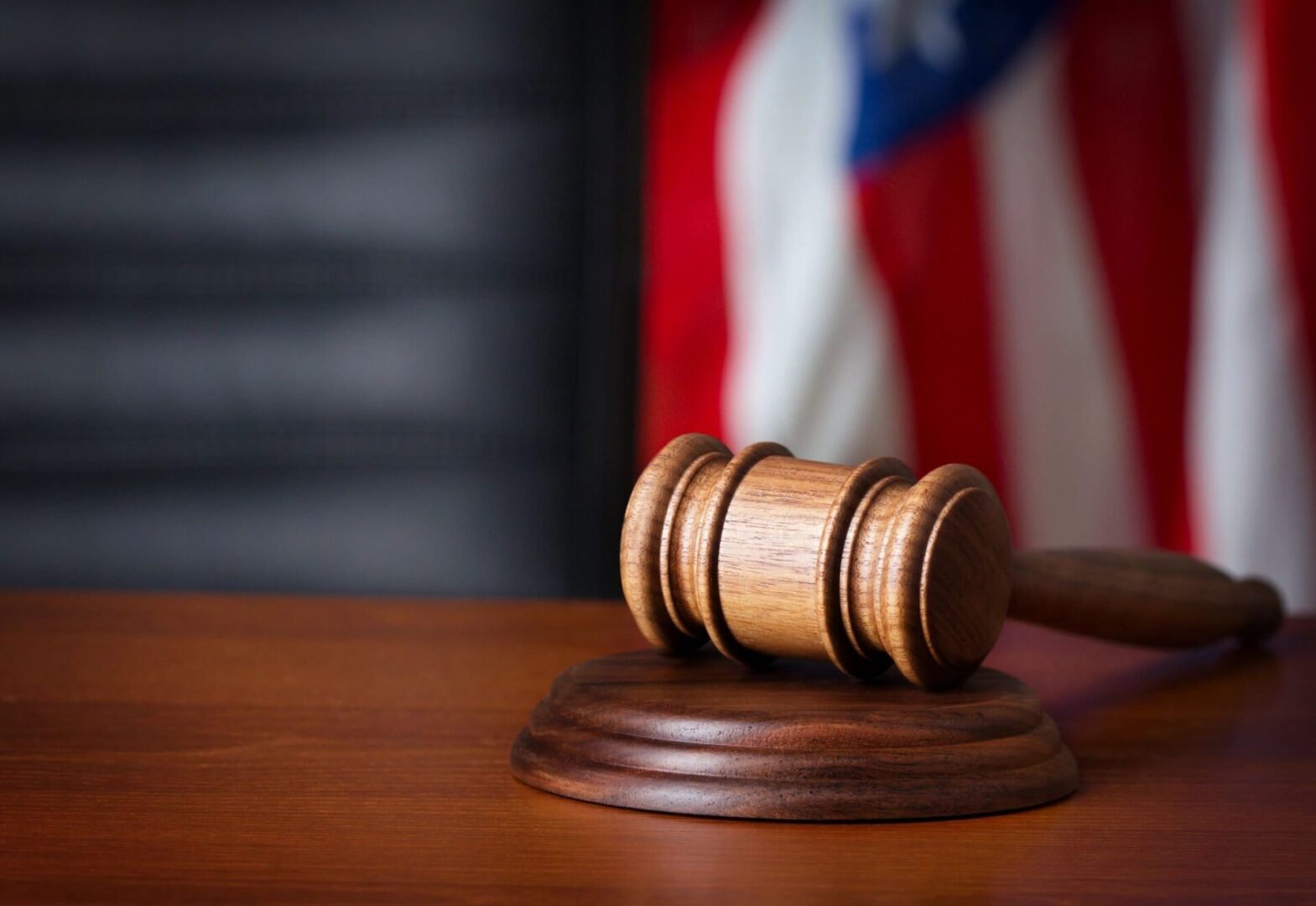 Court hammer on table with flag in background